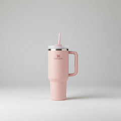 Pink Stanley tumbler with handle on a light beige background