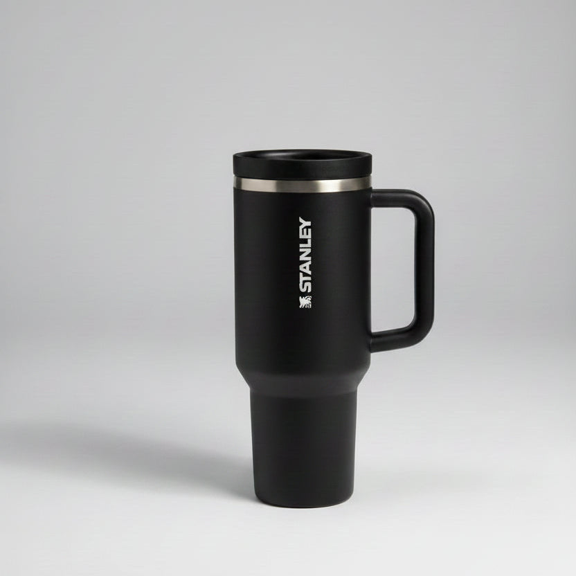 black-colored travel mug with handle on a gray background
