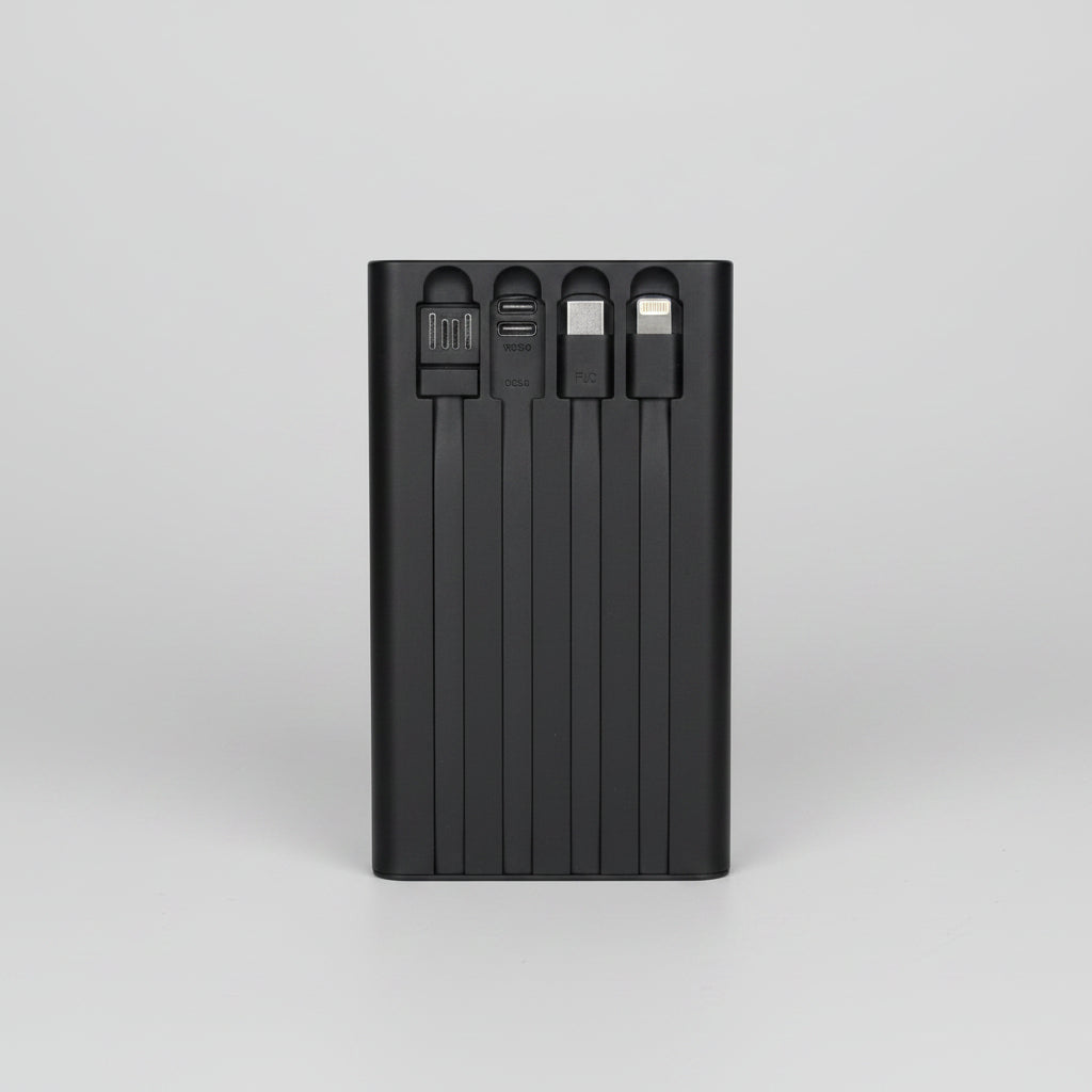 Black multi-port USB charger held in a hand with a blurred background