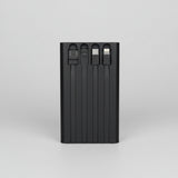 Black multi-port USB charger held in a hand with a blurred background