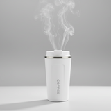  white coffee tumblers with steam rising from the black one on a wooden surface.